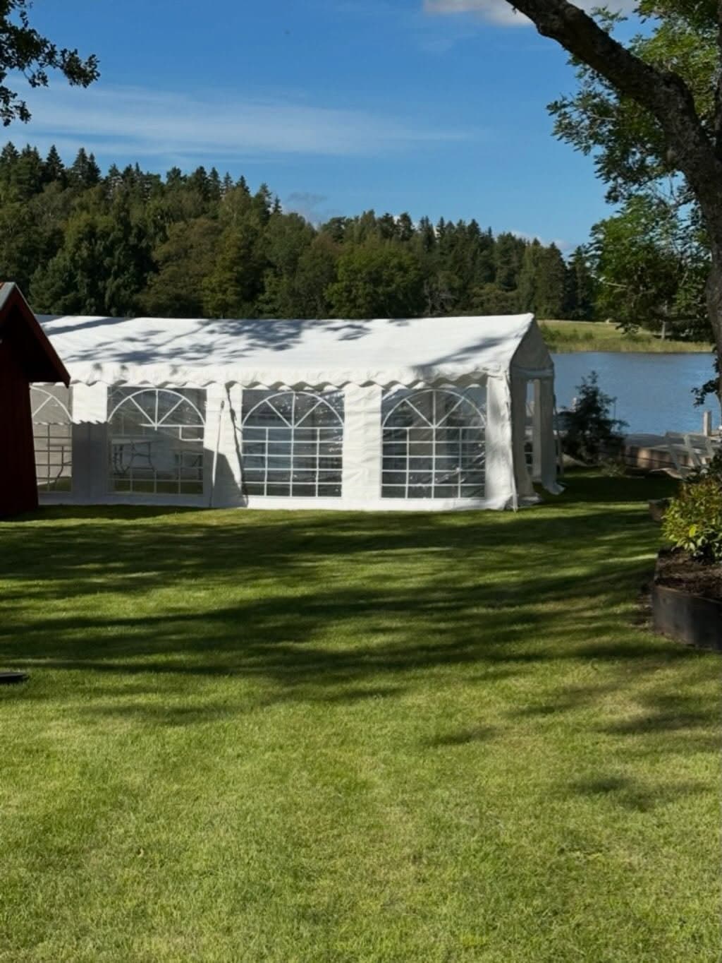 Partytält på gräsmatta med sjöutsikt