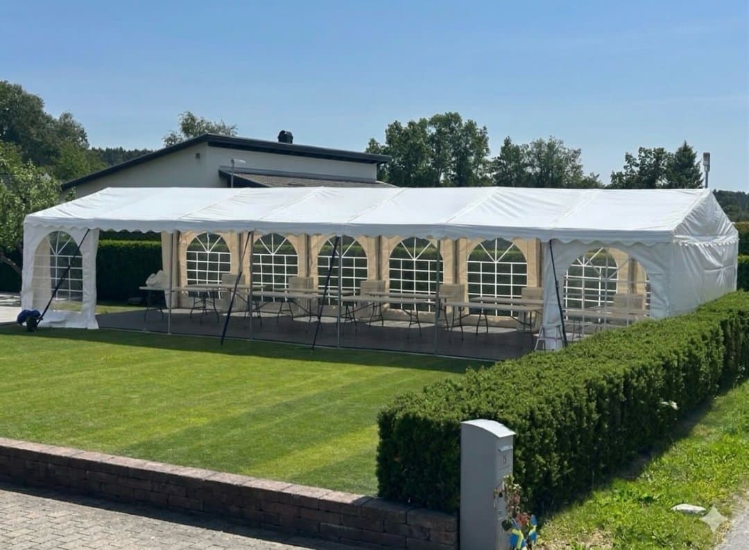 Partytält uppställt i en trädgård